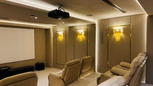 Luxury home theatre system in Dubai featuring comfortable recliners, wall-mounted acoustic panels, and ambient lighting.