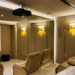 Luxury home theatre system in Dubai featuring comfortable recliners, wall-mounted acoustic panels, and ambient lighting.