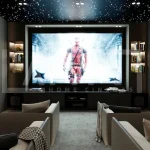 Modern home cinema room size with a large projection screen, luxury recliner seating, acoustic wall panels, KEF speakers, and fiber optic ceiling lighting.