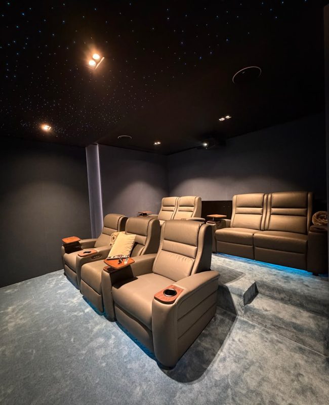 Home Cinema Room Size Guide: How Much Space Do You Really Need? 22 Luxury home cinema showing the ideal home cinema room size with projector screen, reclining seats, KEF speakers, acoustic wall panels, and fiber optic lighting in a Dubai villa.