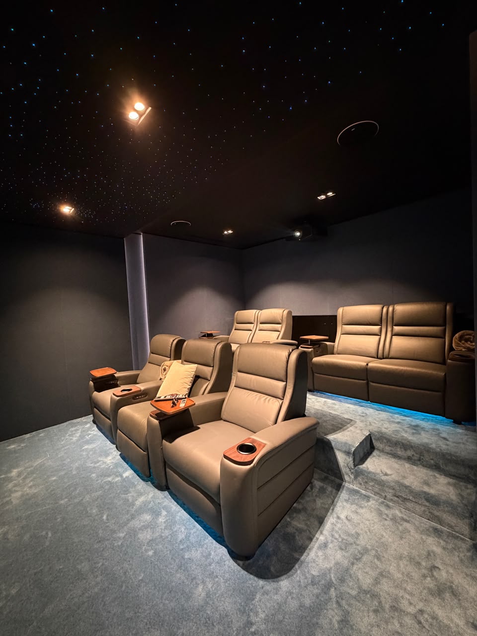 Home Cinema Room Size Guide: How Much Space Do You Really Need? 14 Luxury home cinema showing the ideal home cinema room size with projector screen, reclining seats, KEF speakers, acoustic wall panels, and fiber optic lighting in a Dubai villa.
